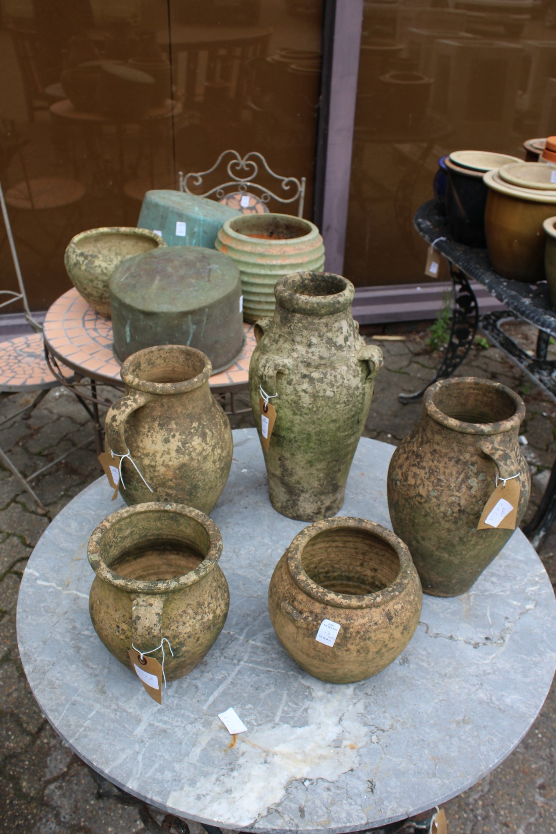 Terracotta and stoneware pots and two old copper saucepans.