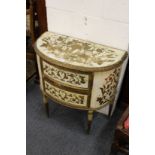 A continental style painted and gilded demi-lune two-drawer commode.