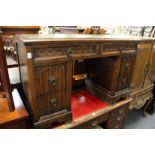 A carved oak pedestal desk.