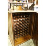 A pine cupboard containing a wine rack.