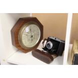 A folding camera and a barometer.