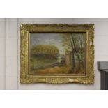 A river landscape with buildings and trees, oil on canvas, in a decorative gilt frame.