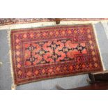 A small red ground Persian rug.