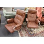 A pair of swivel reclining armchairs.