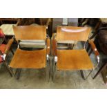 A pair of leather upholstered and chrome framed cantilever style armchairs.