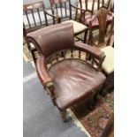 A Victorian oak framed and leather cloth upholstered desk chair.