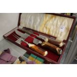 A cased carving set with antler handles.