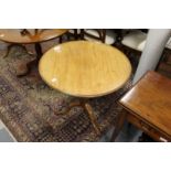 A George III mahogany tilt top tripod table with dished top, turned and carved column supports, on