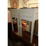 A pair of cream painted bedside tables.