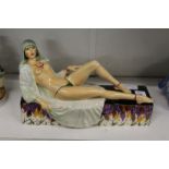 Peggy Davis, a painted porcelain figure of a semi nude female reclining on a rectangular base.