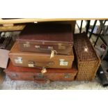 Three suitcases and a wicker hamper.