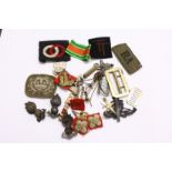 A quantity of military cap badges, buckles and other related items.