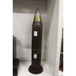 An early military shell mounted on a mahogany plinth base.