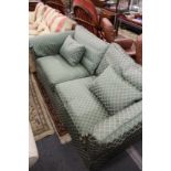 A classic style large two-seater green upholstered settee.