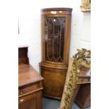 A mahogany standing corner cabinet.