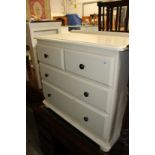 A cream painted bedroom chest.