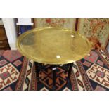 An eastern brass tray top table with folding base.