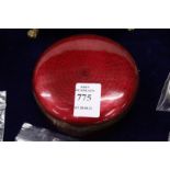 A red Guilloche enamel circular box and cover.