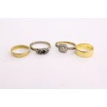A 22ct gold small wedding band and three other rings.