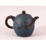 A CHINESE YIXING CLAY TEAPOT - with a blue ground and raised prunus decoration, the base with an