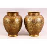 A PAIR OF PERSIAN BRASS VASES, with profusely engraved and chased decoration, 17cm high.