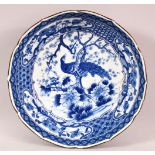 A JAPANESE MEIJI BLUE & WHITE PORCELAIN DISH - decorated with a peacock amongst flora, base