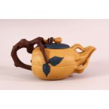 A CHINESE YIXING CLAY TEAPOT - with a beige ground, the pot in the form of a fruit, with vine growth