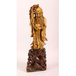 A CHINESE CARVED SOAPSTONE FIGURE - SHOU LAO - the figure of the immortal stood holding a staff