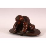 A CHINESE BRONZE FIGURE OF A BOY PLAYING - the boy knelt upon a play mat, 10cm