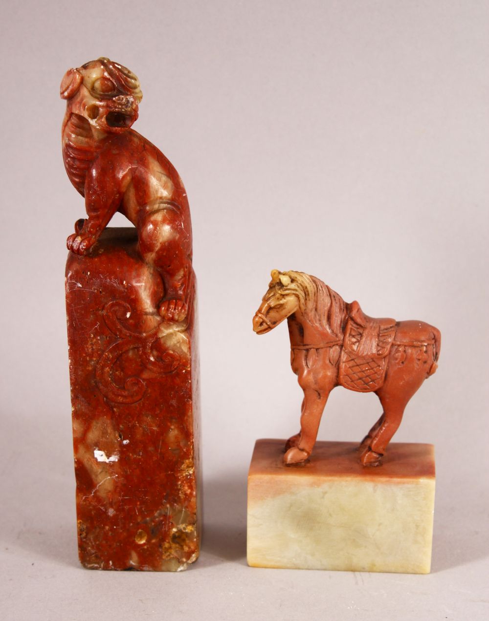 TWO CHINESE CARVED SOAPSTONE SEALS, one carved with lion dog, the other with a horse, 13.5cm and 8cm