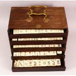 A CHINESE 20TH CENTURY MAH JONG SET IN WOODEN BOX - comprising 144 pieces of bamboo & bone tiles,