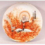 A CHINESE IRON RED PORCELAIN LOUHAN PLATE, the plate decorated with scenes of a seated luohan,