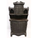 A SUPERB CEYLONESE CARVED EBONY CABINET, with broken arch pediment above a pair of bow fronted doors