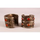 TWO ISLAMIC SILVER BANGLES, inset with stones - possibly amber.