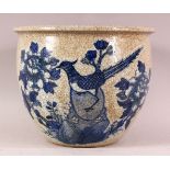 A CHINESE CRACKLE GLAZED PORCELAIN PLANT POT - decorated in underglaze blue of a bird amongst flora,