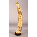 AN IMPRESSIVE LARGE CHINESE IVORY TUSK CARVING OF A STANDING GUANYIN, her left hand raised, her