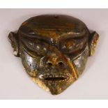 A CHINESE CARVED MOSS JADE HONG SHAN MASK - 20cm wide