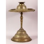 AN ISLAMIC BRASS CANDLESTICK, engraved with bands of calligraphy and decorative motifs, comprised of