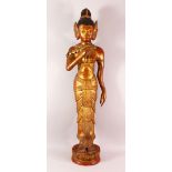 A LARGE THAI GILT AND RED LACQUER CARVED WOOD FIGURE, standing on a lotus base, 104cm high.