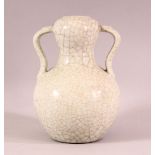 A CHINESE CRACKLE GLAZED PORCELAIN TWIN HANDLE VASE, the base with gilt calligraphy, 19cm high