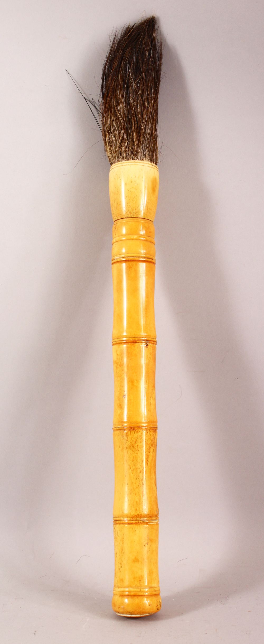 A LARGE CHINESE BONE HANDLED CALLIGRAPHY BRUSH, 50cm long.