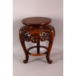 A JAPANESE CARVED HARDWOOD TRIPOD STAND - with a carved frieze of floral form, housing a vase or