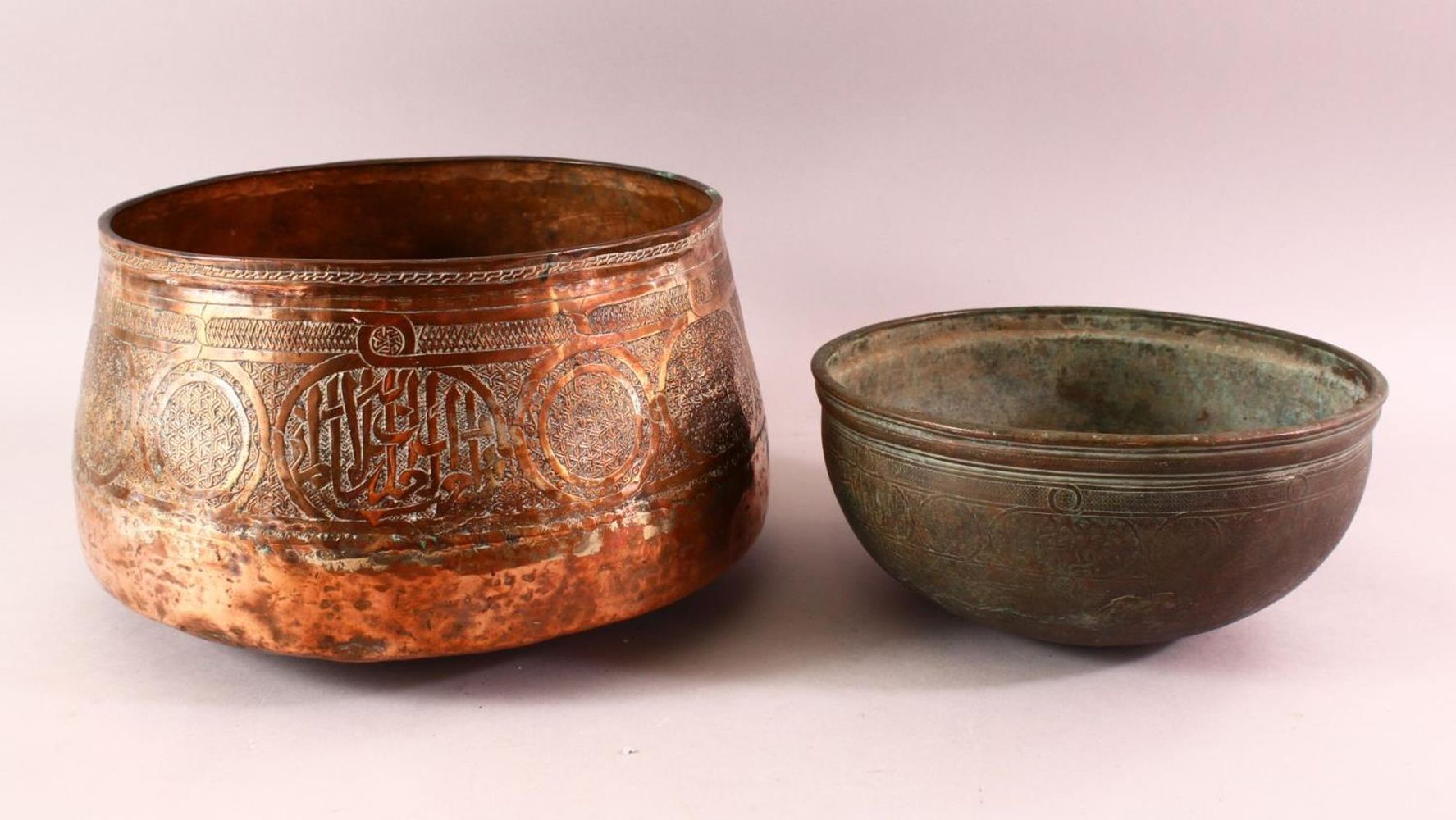 TWO EARLY MAMLUK COPPER BOWLS, each with engraved decoration, 25cm and 28cm diameter.