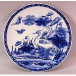 A JAPANESE BLUE & WHITE PORCELAIN PLATE, poss arita, decorated with a bird amongst lotus, the