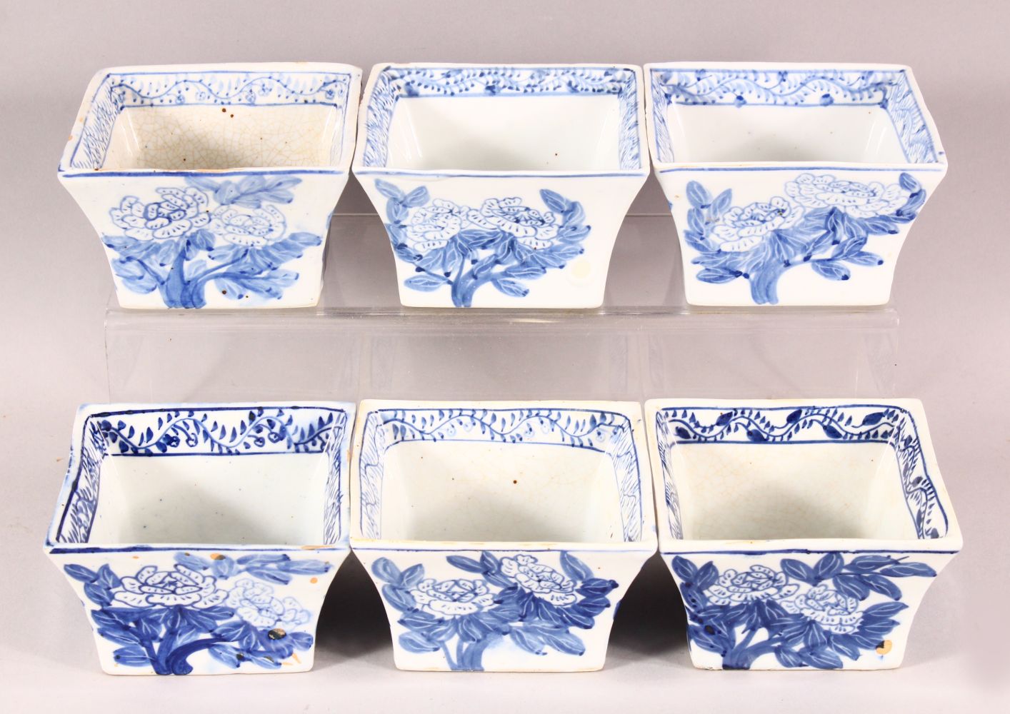 SIX DECORATIVE CHINESE BLUE AND WHITE SQUARE FORM BOWLS, each painted with flowers, the inner rims