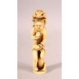 A JAPANESE CARVED IVORY OKIMONO of a boy eating peaches with a toad on his back and a toad at his