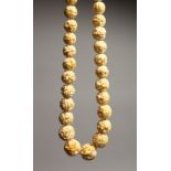 A CARVED IVORY GRADUATED BEAD NECKLACE on fifty eight beads 26ins long