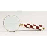 A MAGNIFYING GLASS WITH CHEQUERED HANDLE.