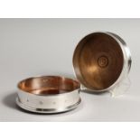 A PAIR OF MODERN PLAIN SILVER WINE WINE COASTERS wit turned wood bases 4.75diameter London 2003