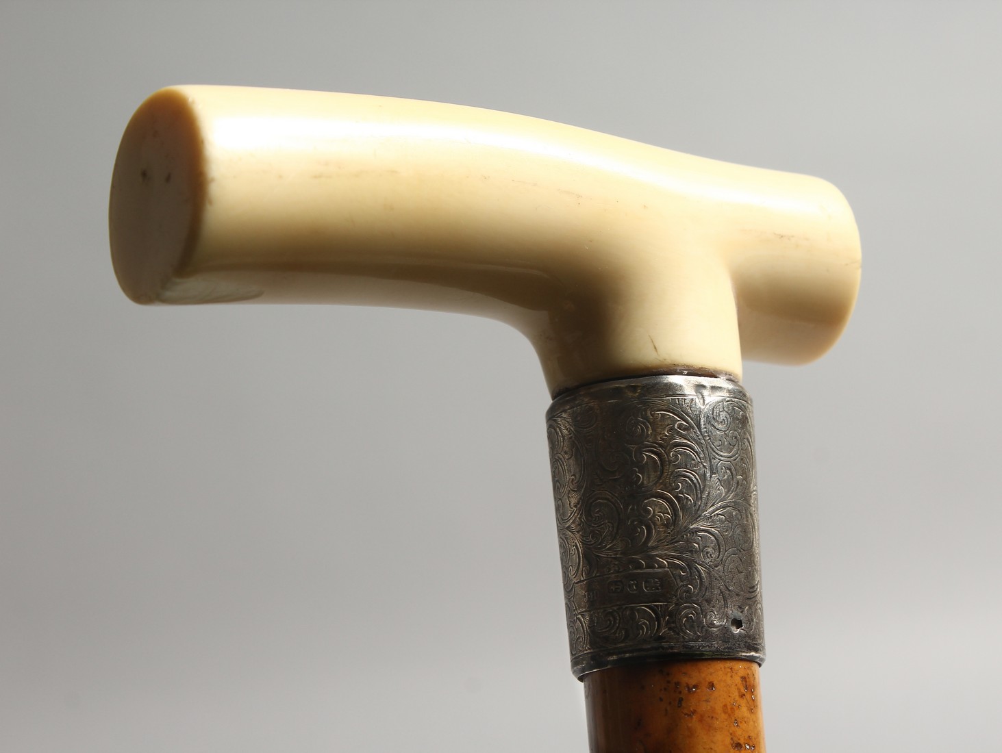 A GOOD VICTORIAN CARVED IVORY HANDLE WALKING STICK with silver band.